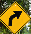 Alberta curve right warning sign — yellow diamond with a black arrow bending to the right